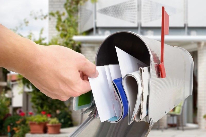 Close-up Of Man's Hand Taking Letter From Mailbox Outside House Close-up Of Man's Hand Taking Letter From Mailbox Outside House